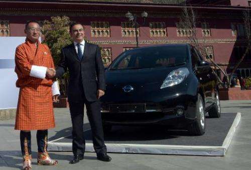 Nissan Motor CEO, Carlos Ghosn (R), and Bhutanese Prime Minister, Tshering Tobgay, unveil the Nissan Leaf electric vehicle in Th