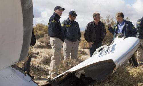 NTSB Acting Chairman Christopher Hart(2nd-L), Virgin Galactic pilot Todd Ericson(C) and investigators survey a section of the Sp