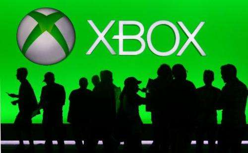 People are silhouetted against an Xbox display at annual E3 video game extravaganza in Los Angeles, California on June 10, 2014