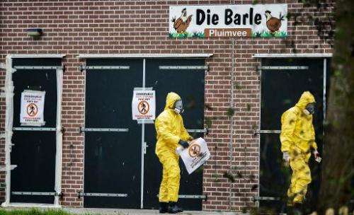 People in protective gear walk by the poultry farm where a new outbreak of bird flu has been found in Zoeterwoude, The Netherlan