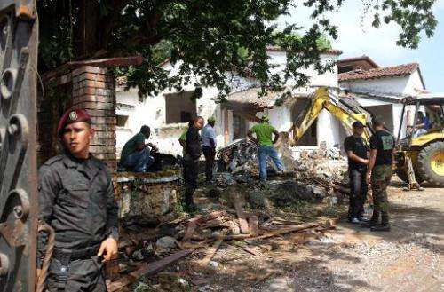 Police stand guard at the residence of Panama's former dictador Manuel Antonio Noriega, as it is demolished on January 9, 2014 f