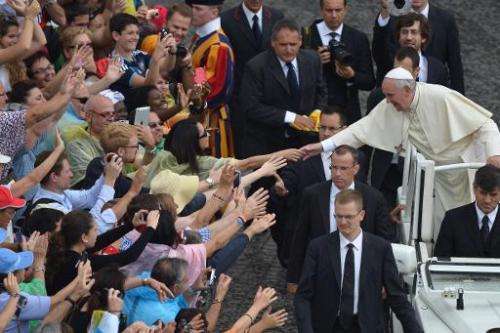 Pope Francis greets the crowd as he arrives for his general audience at St Peter's square on June 25, 2014 at the Vatican