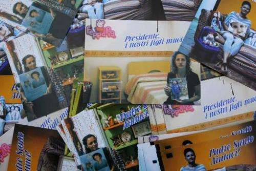Postcards displayed in Caivano, southern Italy, on November 14, 2013 show mothers with pictures of their children who died from 