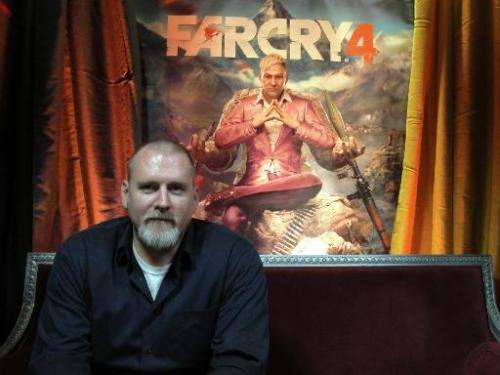 &quot;Far Cry 4&quot; video game executive director Dan Hay sits in front of a poster for the Ubisoft title on October 9, 2014, 
