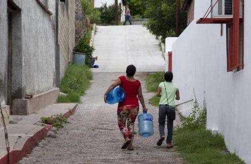 Residents go to collect drinking water in the Arizpe community, Sonora state of Mexico, on August 12, 2014