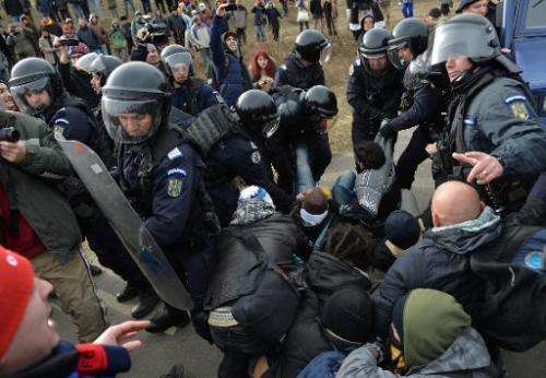 Romanian protesters scuffle with gendarmes after breaking the fence at Chevron's exploratory well in Pungesti, Romania on Decemb
