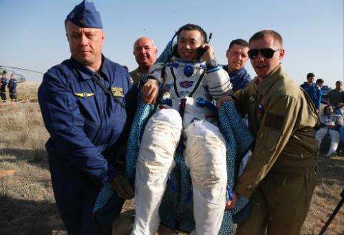 Russian space agency rescue team members carry Japanese astronaut Koichi Wakata shortly after landing, about 150 km south-east o