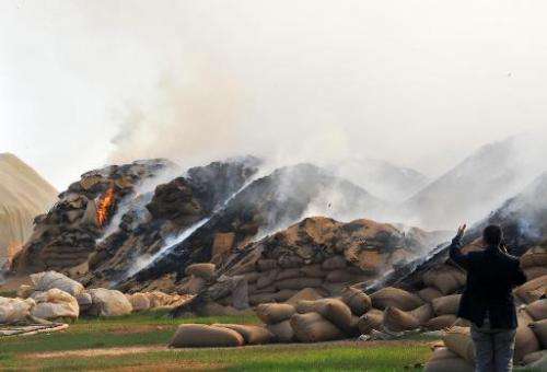 Sacks of wheat burn following Syrian air strikes in the town of Ras al-Ain near the border with Turkey on November 16, 2012