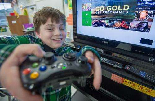 Sawyer Whitely, who is autistic, holds the contoller as he plays selected games on a Microsoft X-box Kinect, at Steuart W. Welle
