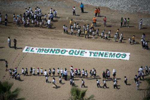 Some 700 Peruvian children form a large image of a tree at Lima's Miraflores beach to send a message about climate change on the