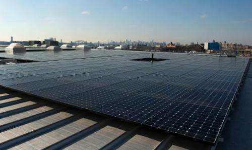 The rooftop of Jetro Restaurant Depot in the Bronx, with a view of Manhattan in the distance,  is covered with solar panels on J