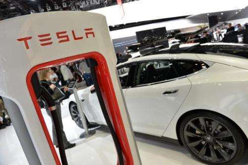 The Tesla P85+ all electric car and its charging station are displayed at the North American International Auto Show on January 