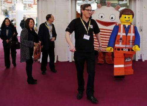 Toy characters walk past visitors during the Toy Fair at Olympia exhibition centre  in London on January 21, 2014