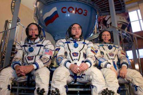 US NASA astronaut Steven Swanson (L) sits together with Russian cosmonauts, Alexander Skvortsov (C) and Oleg Artemyev in front o