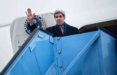 US Secretary of State John Kerry waves while boarding his plane at Franz-Josef-Strauss Airport in Munich, southern Germany, on F