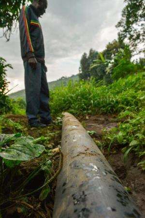 Villagers from Rugari in the Virunga National Park, eastern Democratic Republic of Congo look at a water pipe on June 17, 2014