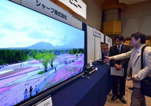 Visitors inspect Japanese electronics maker Sharp's new 4K television and newly developed 4K capable tuner, shown at the launch 