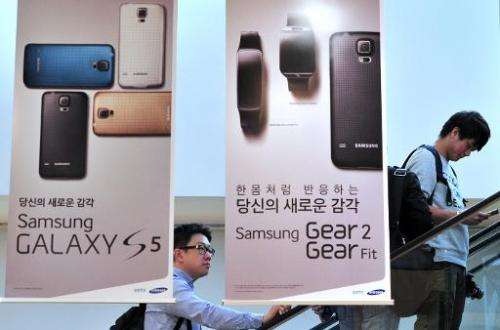 Visitors pass signboards for Samsung Electronics' Galaxy S5 at its showroom in Seoul on April 29, 2014