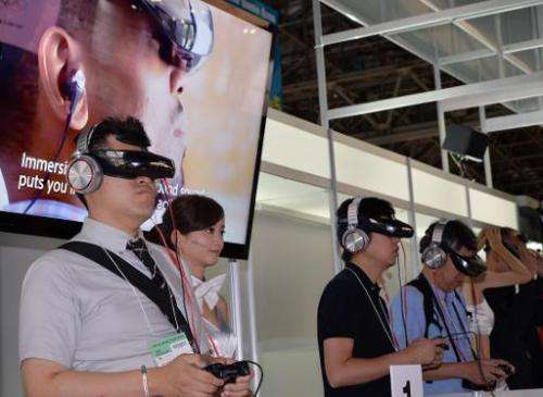 Visitors wear Japanese electronics giant Sony's new head mount display (HMD) 'HMZ-T3' to play videogames at the Tokyo Game Show 