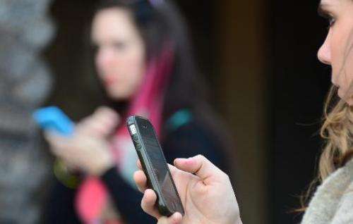 Women use their cellphones on January 7, 2014 in Los Angeles, California