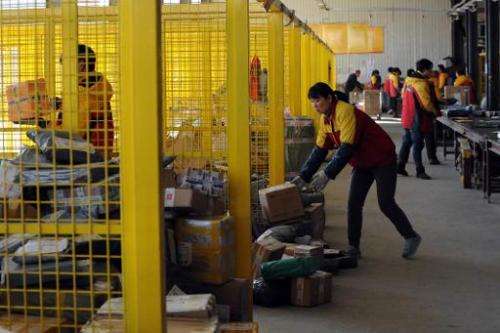 Workers sort out packages at an express delivery company in Beijing on November 12, 2013
