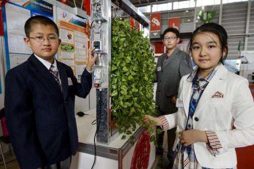 Young inventors from Beijing, China, (from L) Fan Xiyu, Li Peize and Wang Yifan present their creation during the opening day of