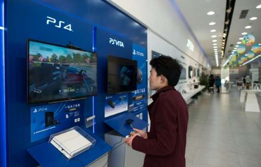 A man plays with a Sony PlayStation 4 in a shop in downtown Shanghai on March 19, 2015