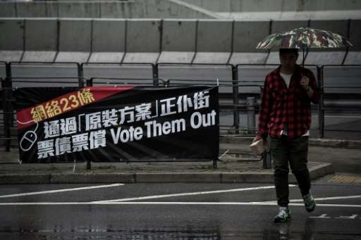 A pedestrian walks past a banner displayed against a proposed bill to regulate the Internet, outside the Legislative (Legco) Cou