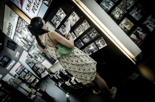 A woman listens to a music CD in a shop in Hong Kong on June 17, 2012