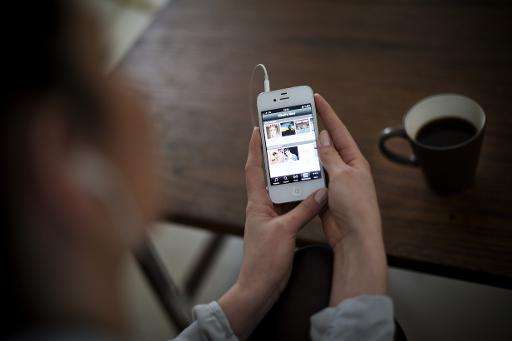 A woman uses the iPhone application of Swedish music streaming service Spotify on March 7, 2013 in Stockholm, Sweden