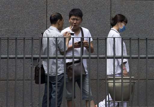 In a nation of smokers, Beijing bans lighting up indoors (Update)