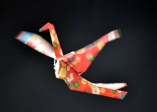 Japan's electronics maker Rohm demonstrate a remote controlled flying paper crane, during a preview of Asia's largest electronic