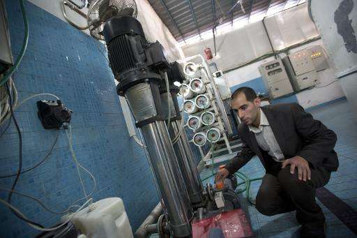 Palestinian engineer Diaa Abu Assi operates a machine that makes seawater potable in Gaza city