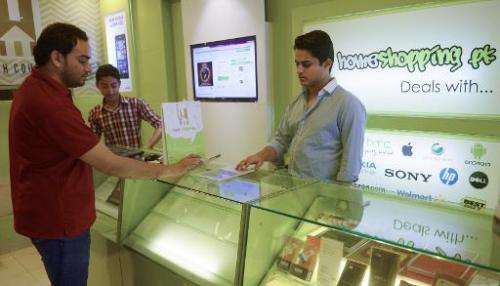Shayaan Tahir (R), CEO of Homeshopping.pk, speaks to a customer at his call centre in Karachi
