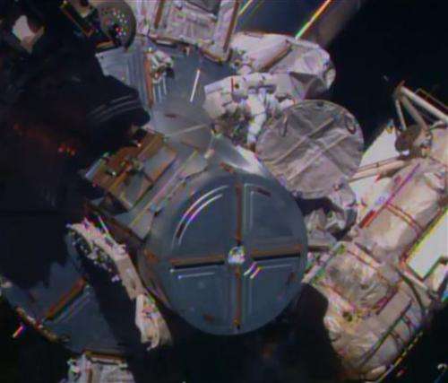 Spacewalking astronauts route cable in 1st of 3 jobs