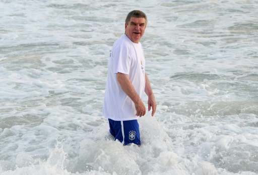 International Olympic Committee president Thomas Bach enters the waters at an event at Barra da Tijuca Beach in Rio de Janeiro, 
