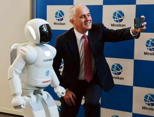 Australian Prime Minister Malcolm Turnbull takes a selfie with Honda Motor's humanoid robot Asimo at the National Museum of Emer