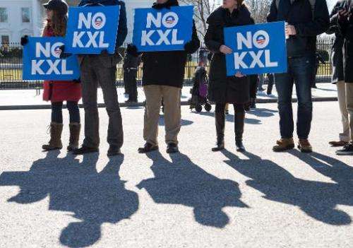 Demonstrators hold signs against the proposed Keystone XL pipeline from Canada to the Gulf of Mexico in front of the White House