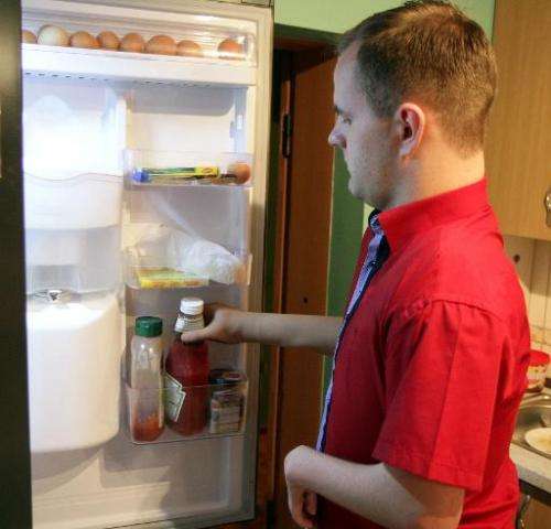 Martynas Girulis uses his new bionic arm to take a bottle of ketchup out of the fridge at his home in Pagegiai, Lithuania