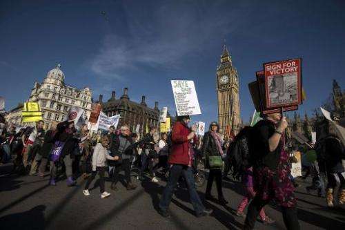 Demonstrators display placards and banners as they walk past the Houses of Parliament during the People's Climate March in Londo