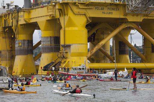 Greenpeace activists paddling in kayaks form a blockade to keep a mammoth Shell oil rig from departing from Seattle on a mission