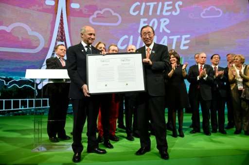 UN Secretary General Ban Ki-moon (R) and France's Foreign Minister Laurent Fabius (L) pose with the Paris City Hall Declaration 