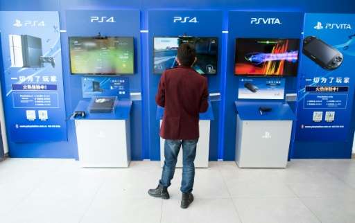 This photo taken on March 19, 2015 shows a man playing with a Sony PlayStation 4 in a shop in downtown Shanghai