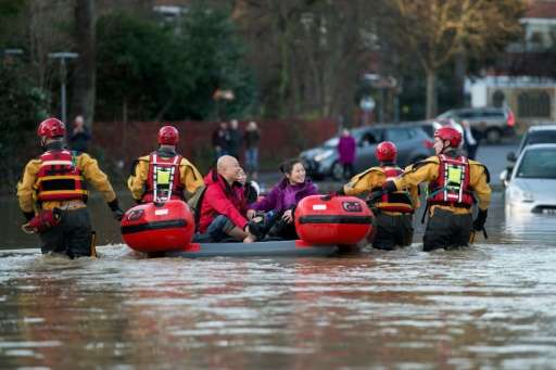 Members of the emergency services transport residents to safety after their homes were flooded in York, northern England, on Dec