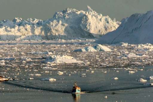A boat skims through the melting ice in the Ilulissat fjord on the western coast of Greenland