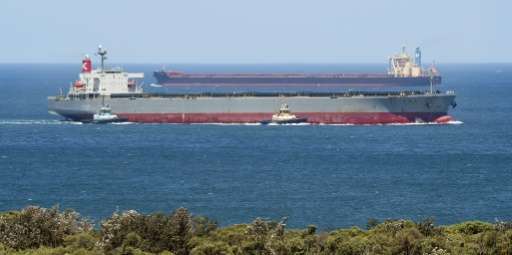 A coal-carrier ship arrives at Australia's Port of Newcastle while another departs
