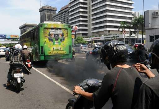 A commuter bus running on diesel fuel emits thick trail of pollutants in Jakarta on December 7, 2009