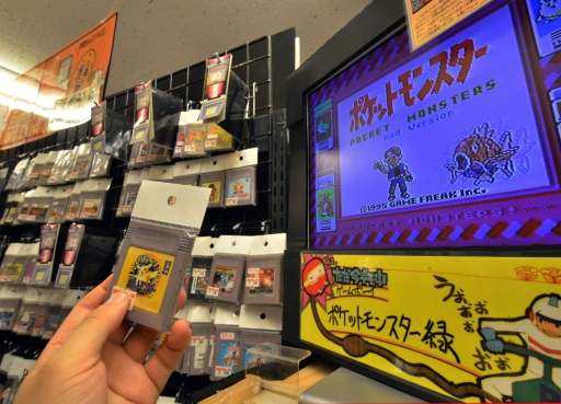 A customer picks up a used videogame software for Nintendo's Game Boy, at shop 'Super Potato' in Tokyo