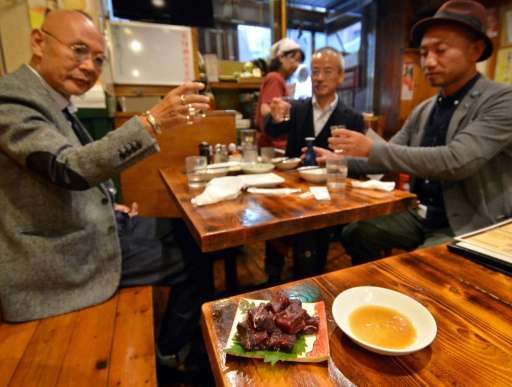 A dish of whale meat sashimi is pictured next to diners at a restaurant in Tokyo during the Ebisu whale meat festival