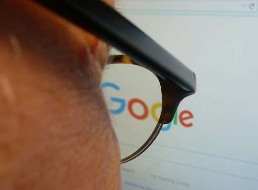 A journalist looks at the new Google logo at his work station in Washington, DC on September 1, 2015